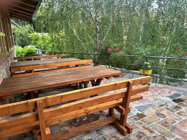 Bašta restorana sa drvenim stolovima