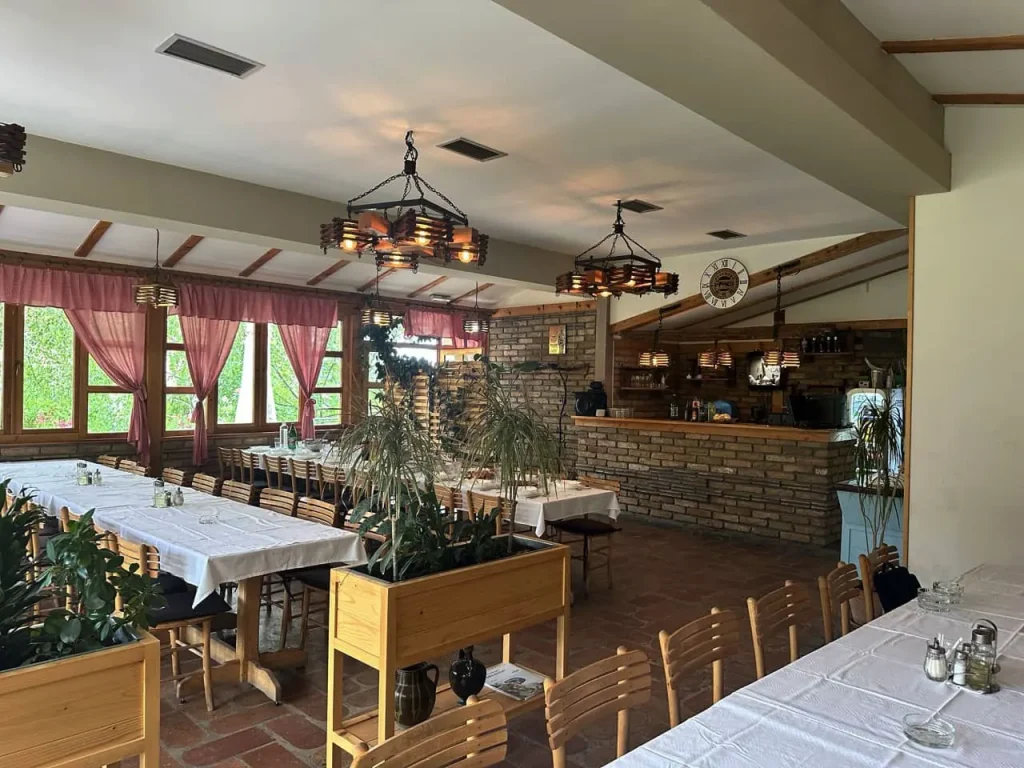 Velika sala Restorana Groš sa dugim stolovima, belim stolnjacima i drvenim lusterima